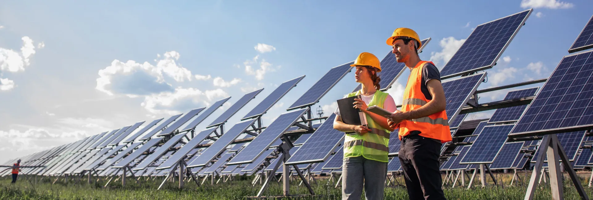 Two people  with solar panels as background